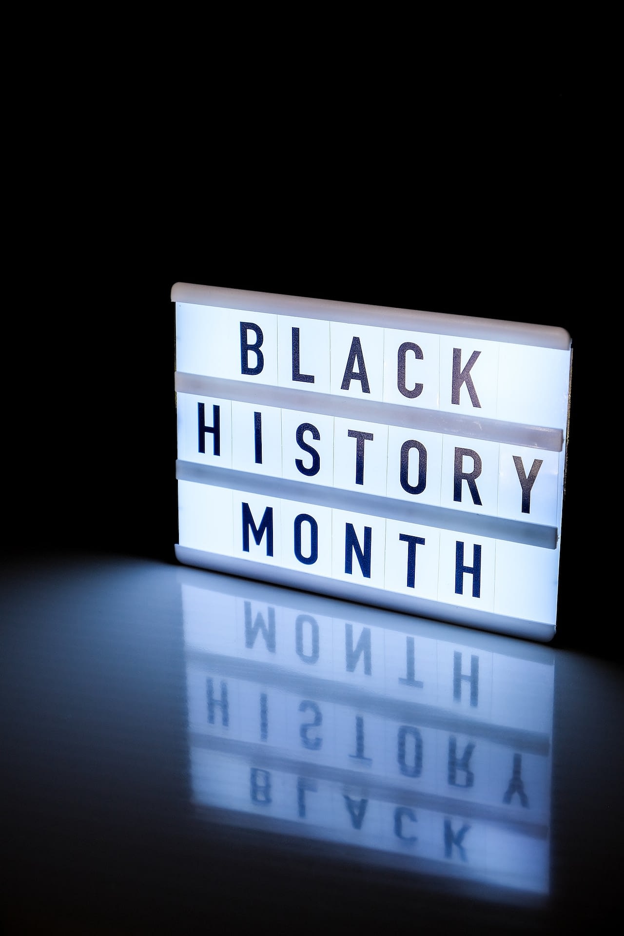 lightbox with text black history month on dark black background with mirror reflection message