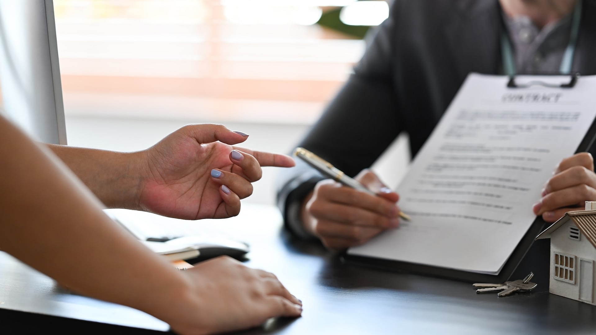 financial advisor consulting with clients about new house and showing contract document