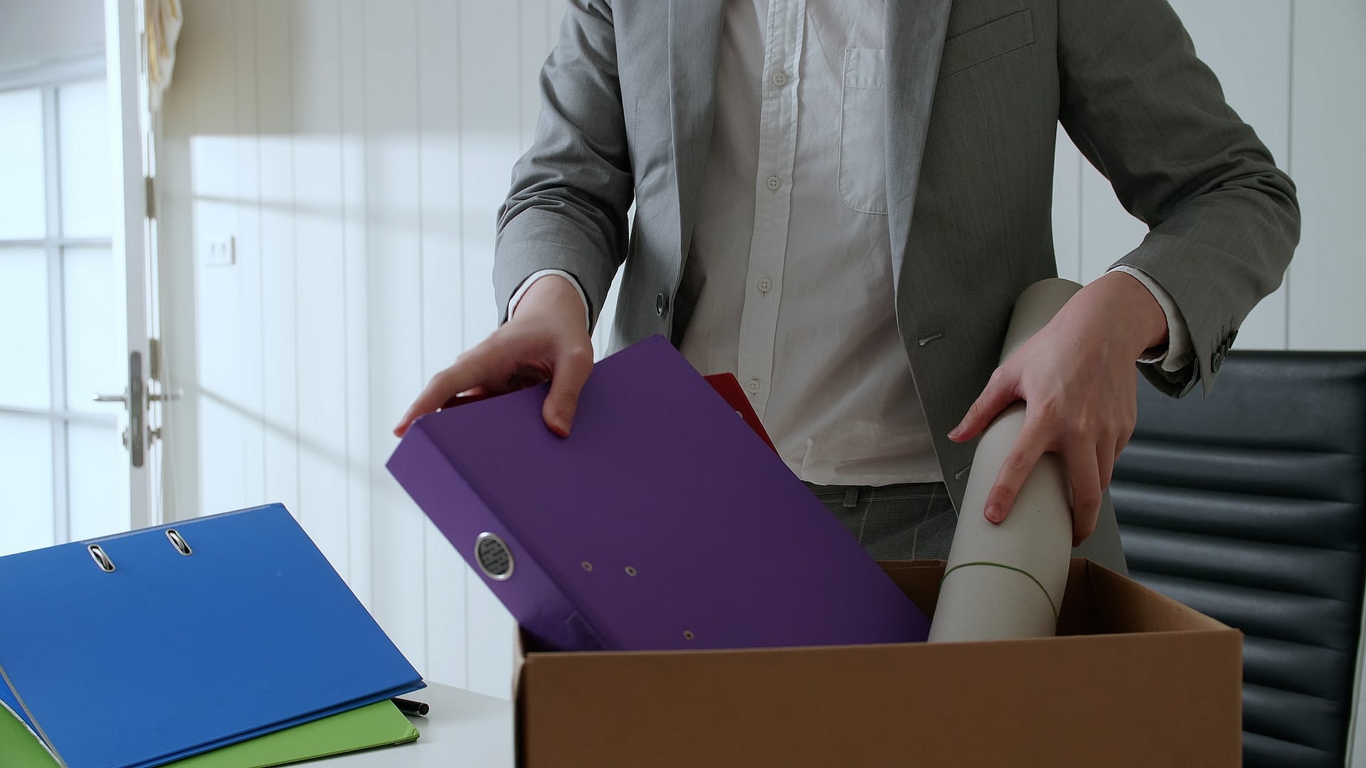 businessman put things and documents on his desk into the paper box