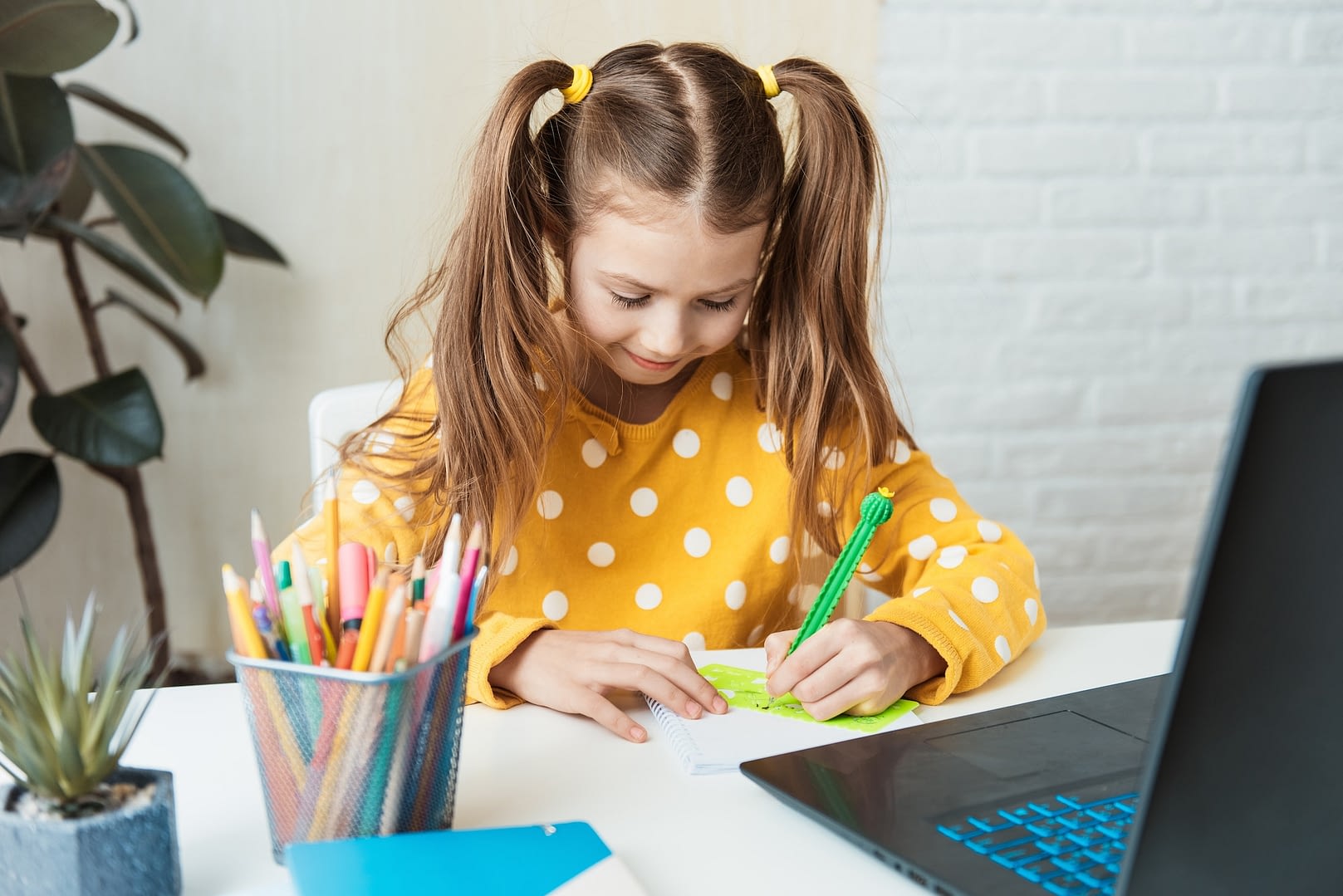 pretty child girl writing notes in notebook daily planner planning week working or studying