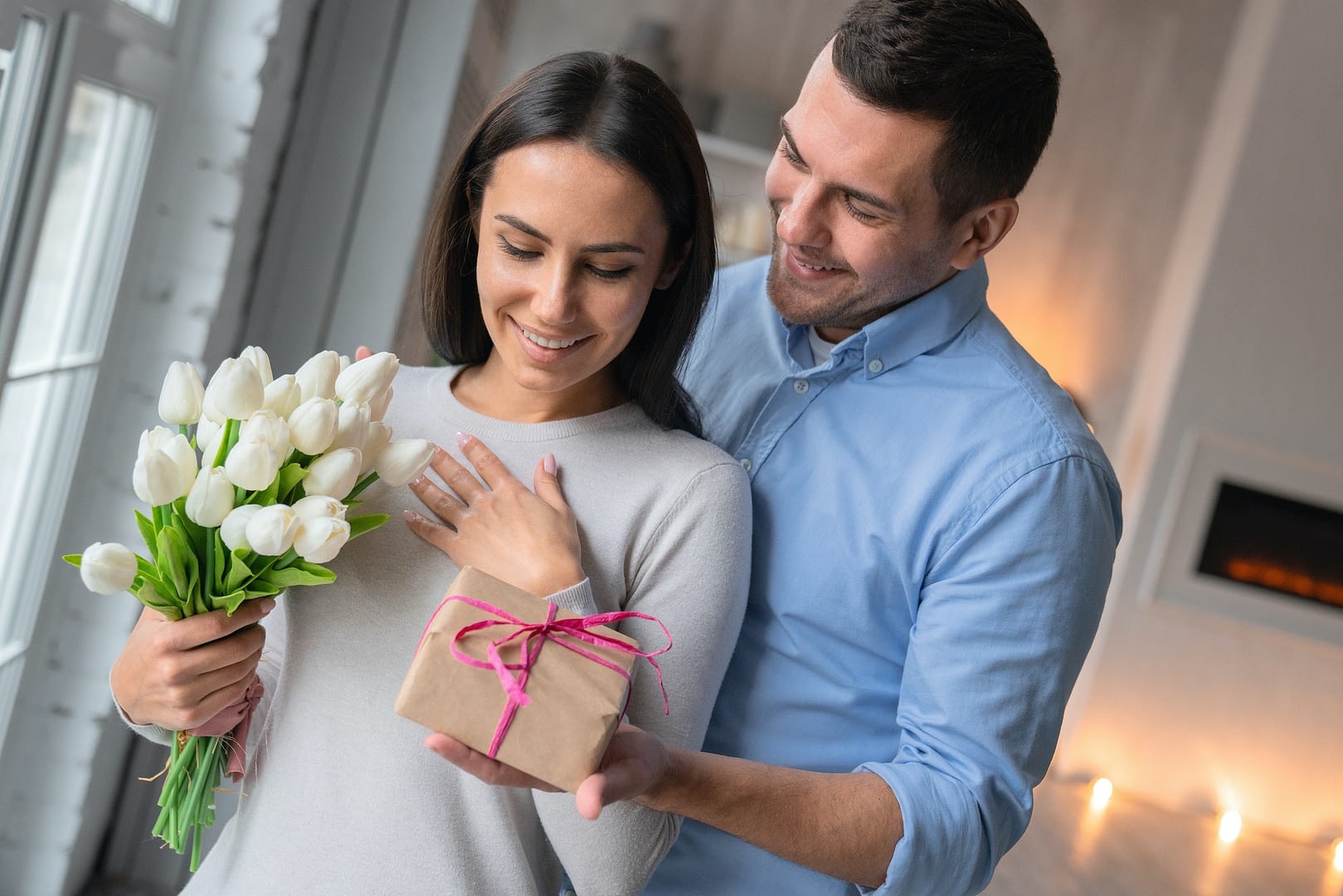 close up shot of cheerful young caucasian man that giving present box to his wife