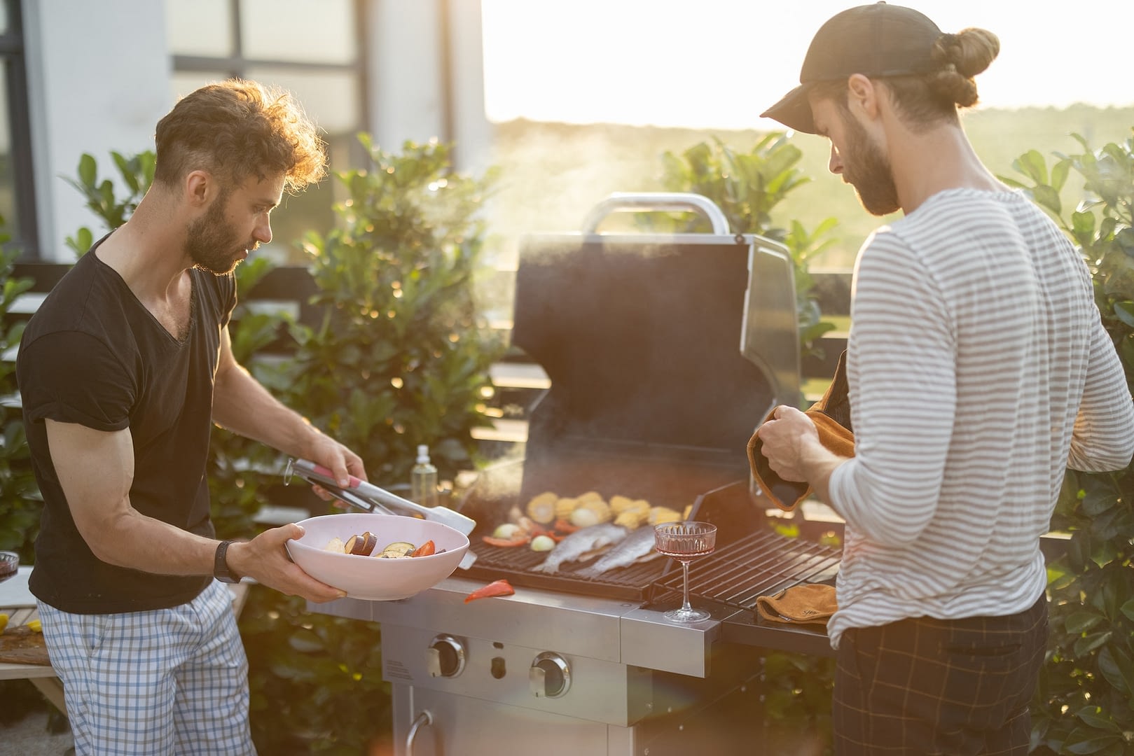 guy grilling at backyard on a sunset