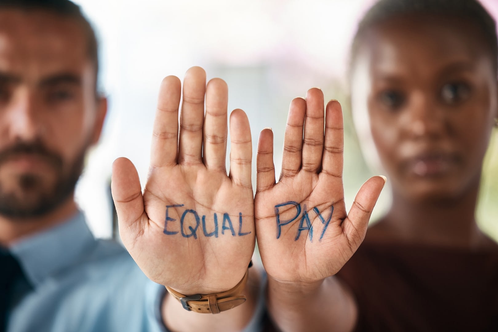 hands equality and empowerment with a business man and woman showing an equal pay notice in their