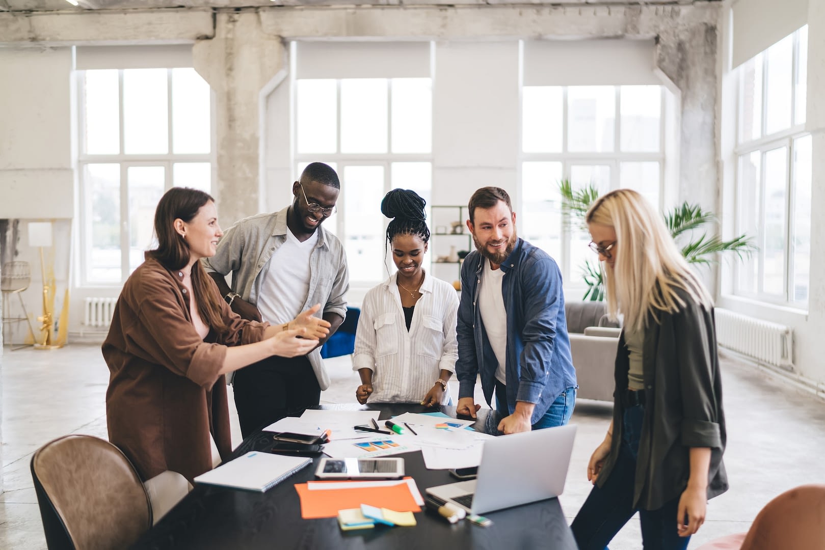 cheerful colleagues working in spacious office and chatting