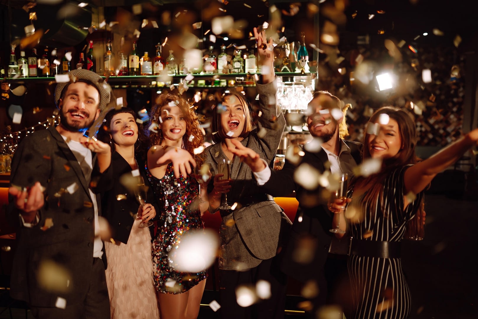 happy friends throwing confetti and jumping while enjoying party confetti is fun party celebration