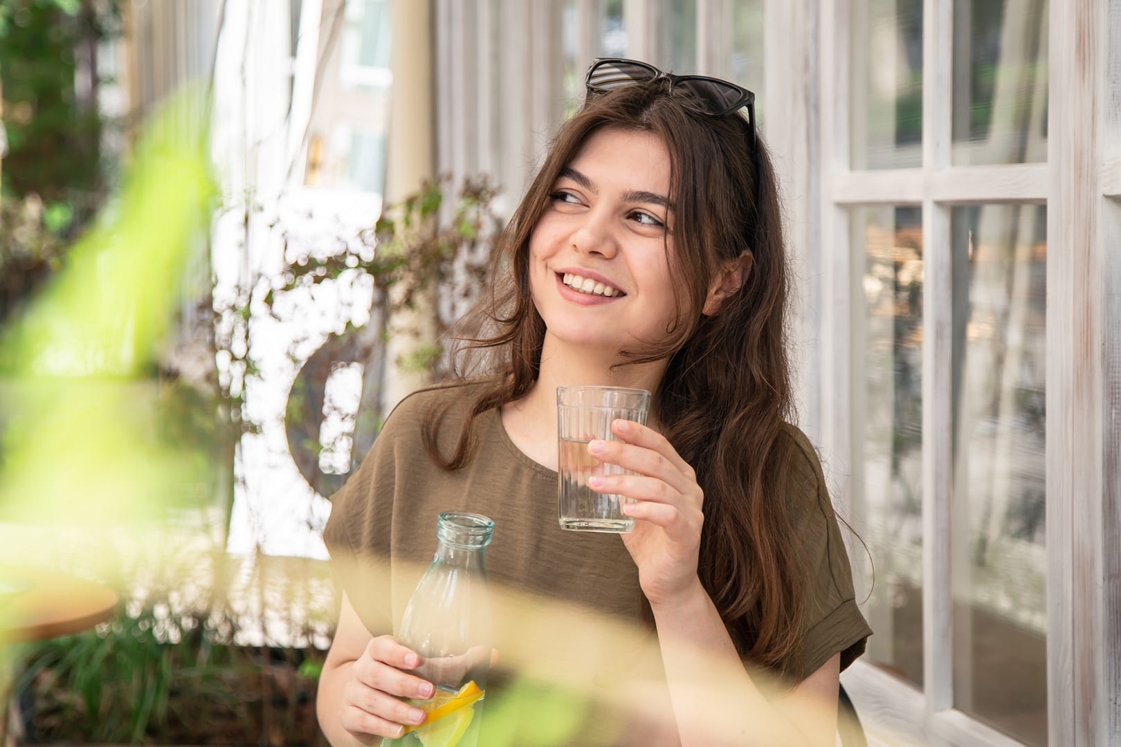 attractive young woman drinks water with lemon