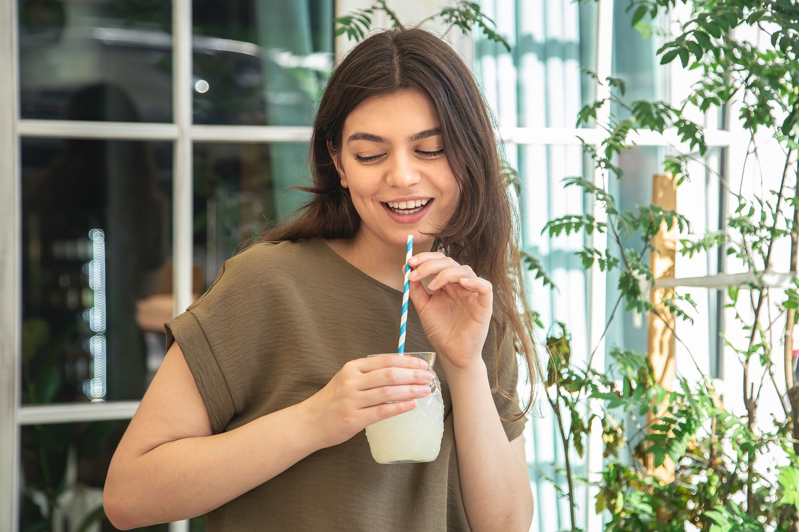 attractive young woman with a glass of lemonade on a hot summer day