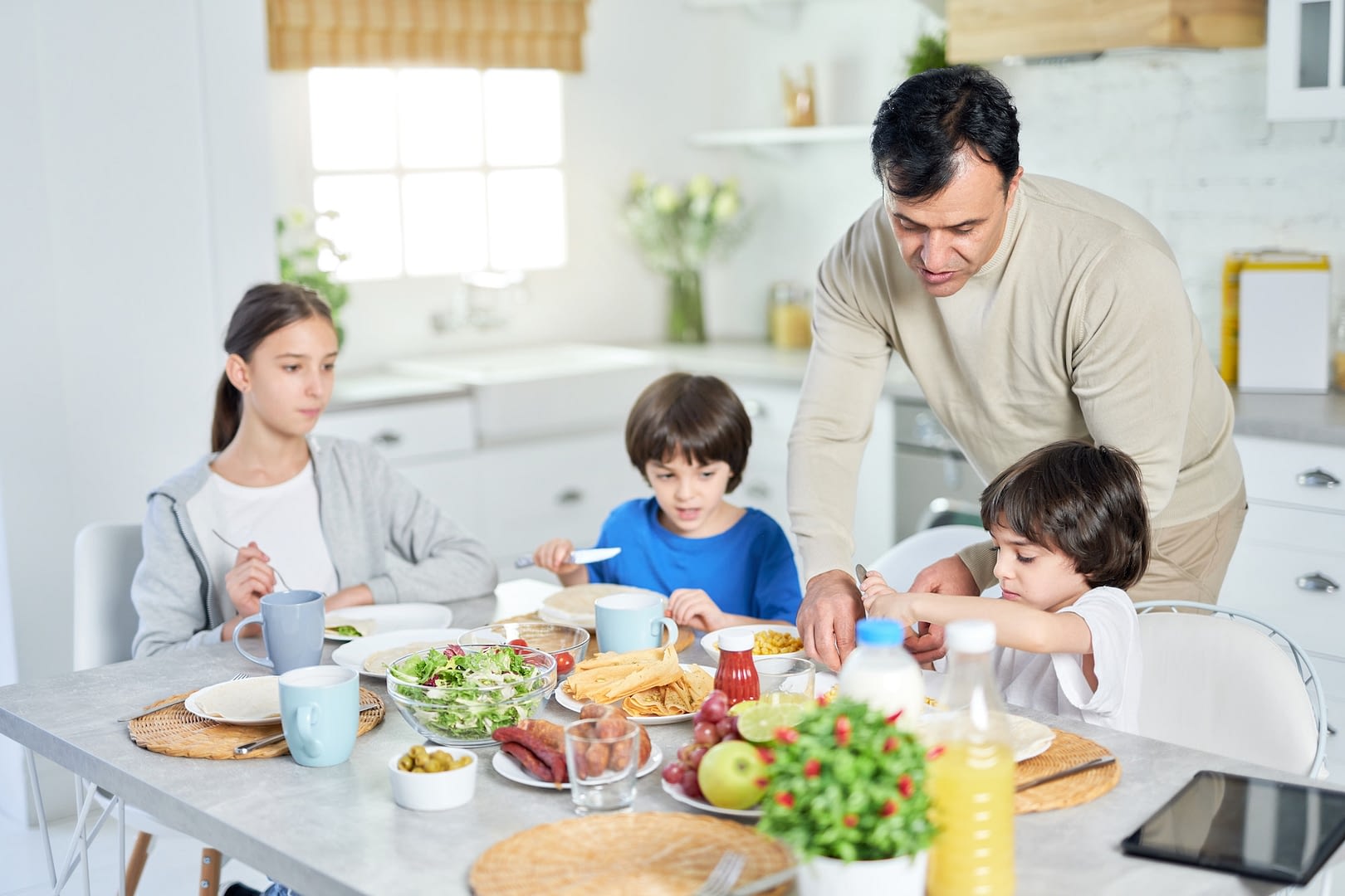 better food better mood loving latin father serving his little children while having breakfast