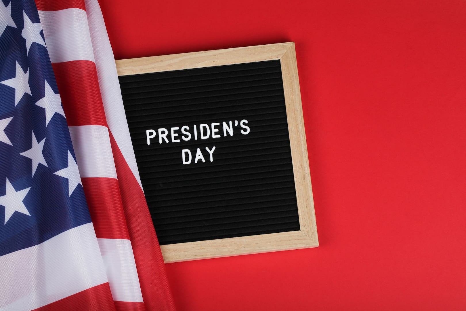 black letter board with text president day and american flag on red background top view flat lay