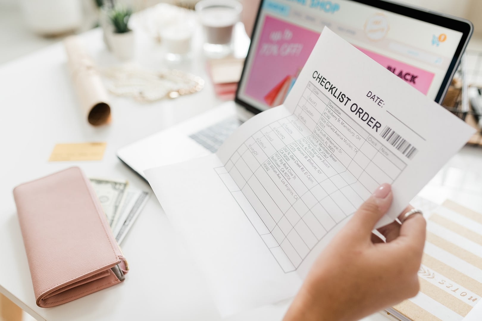 female hand holding paper with checklist after making order in online shop