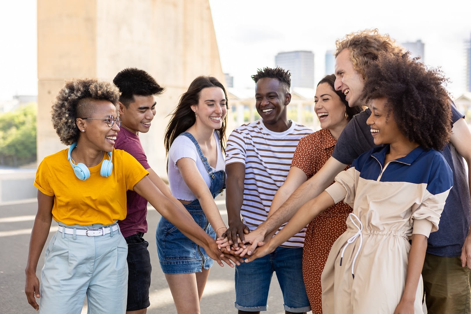 group of young student friends with hands on stack showing international unity