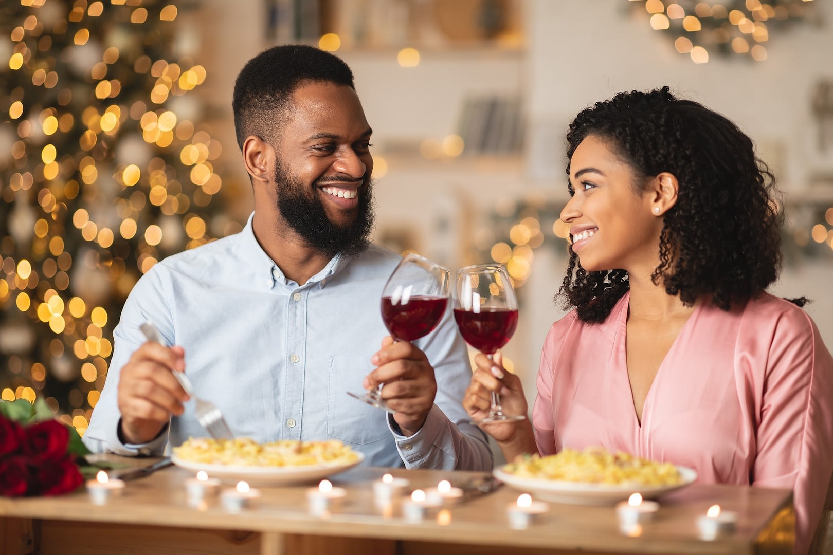 happy black woman and man drinking wine on a date