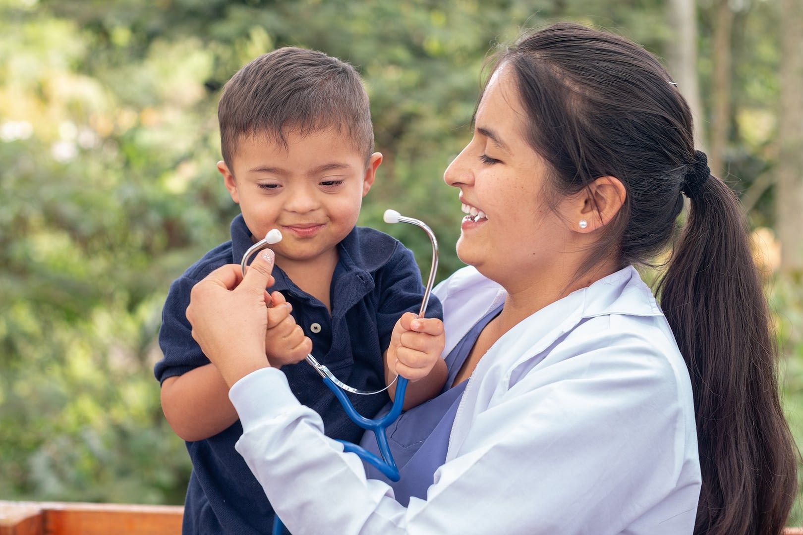 portrait of a doctor and a child with down syndrome smiling together
