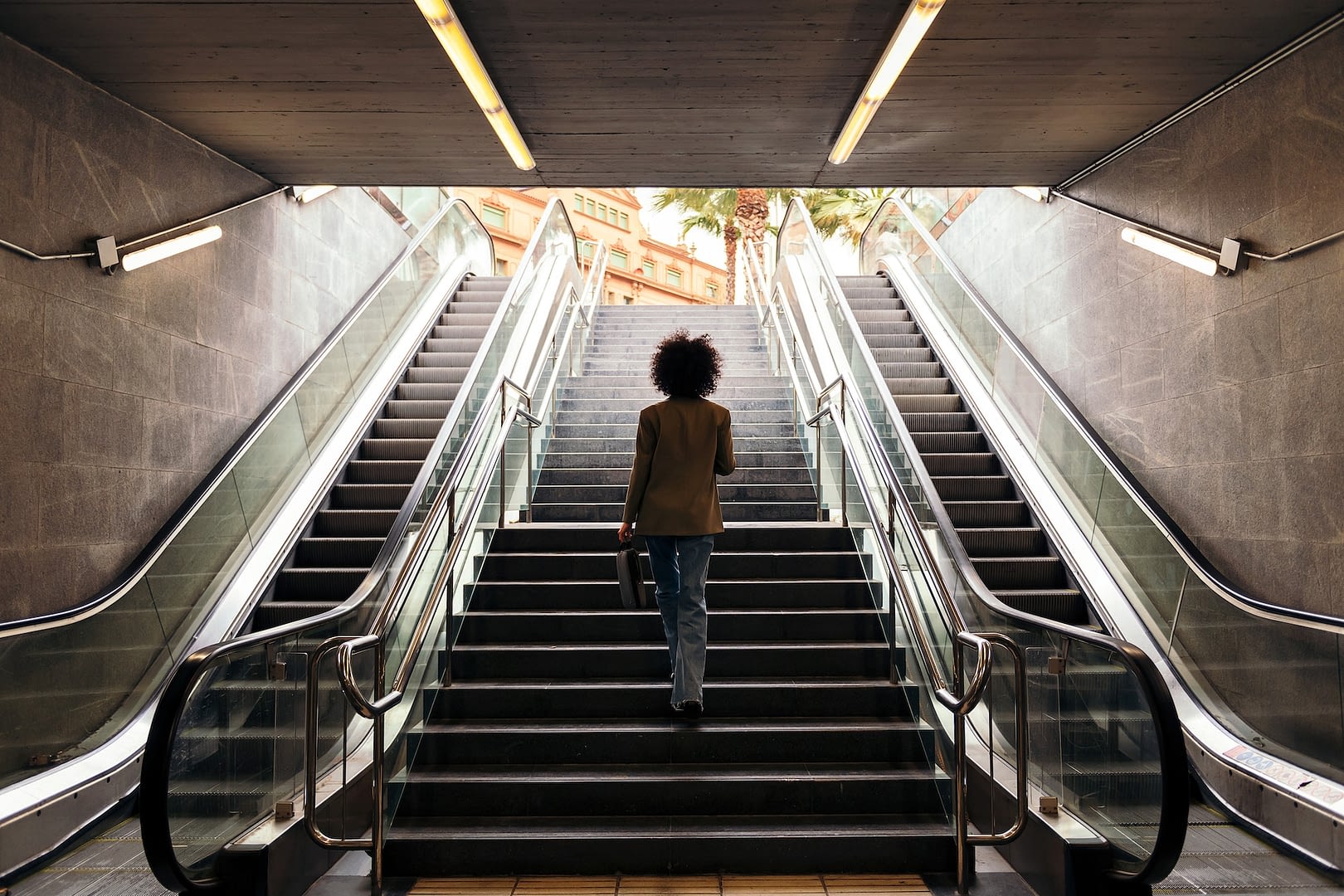 rear view of business woman walking up the stairs