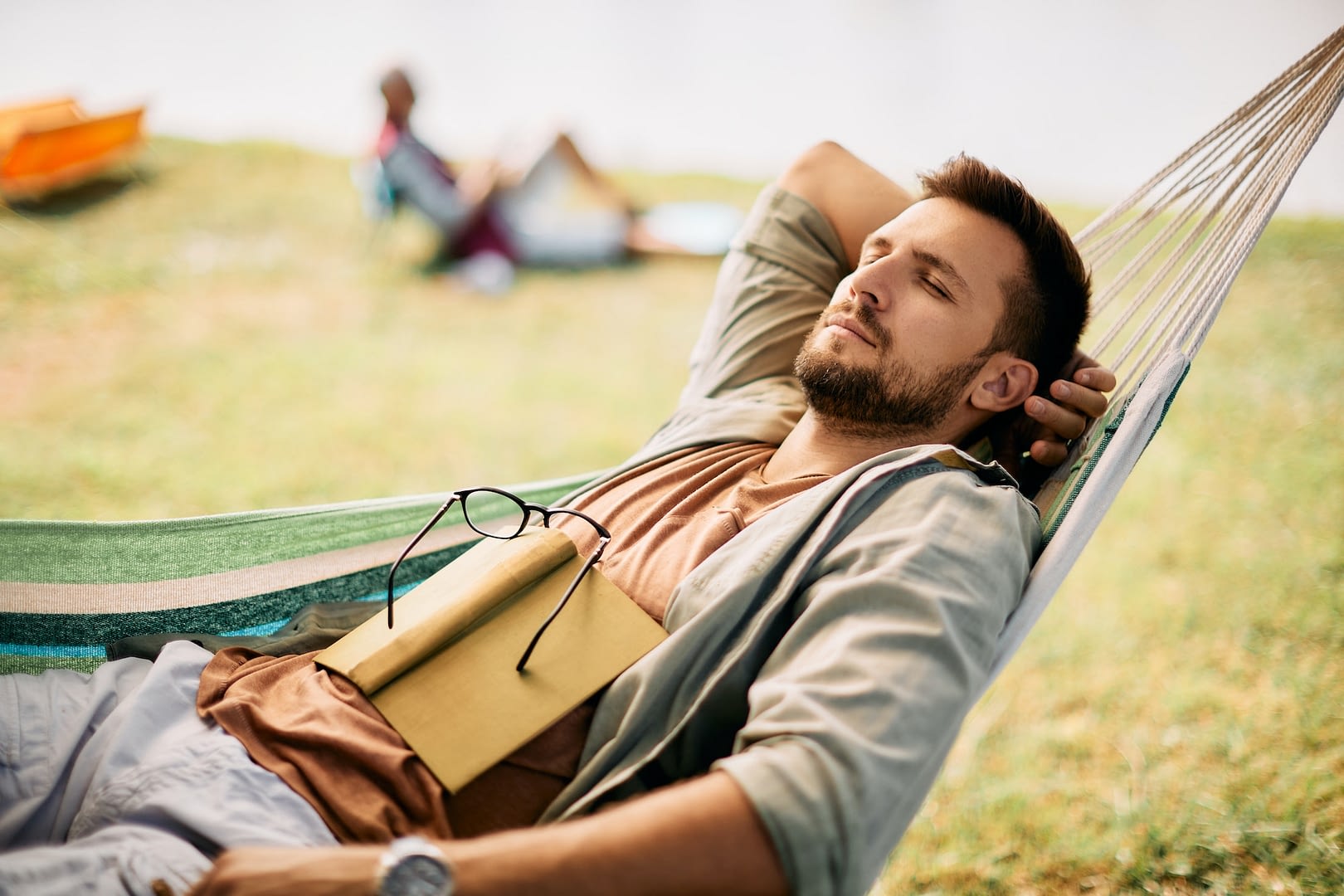 relaxed man napping in hammock while spending a day in nature