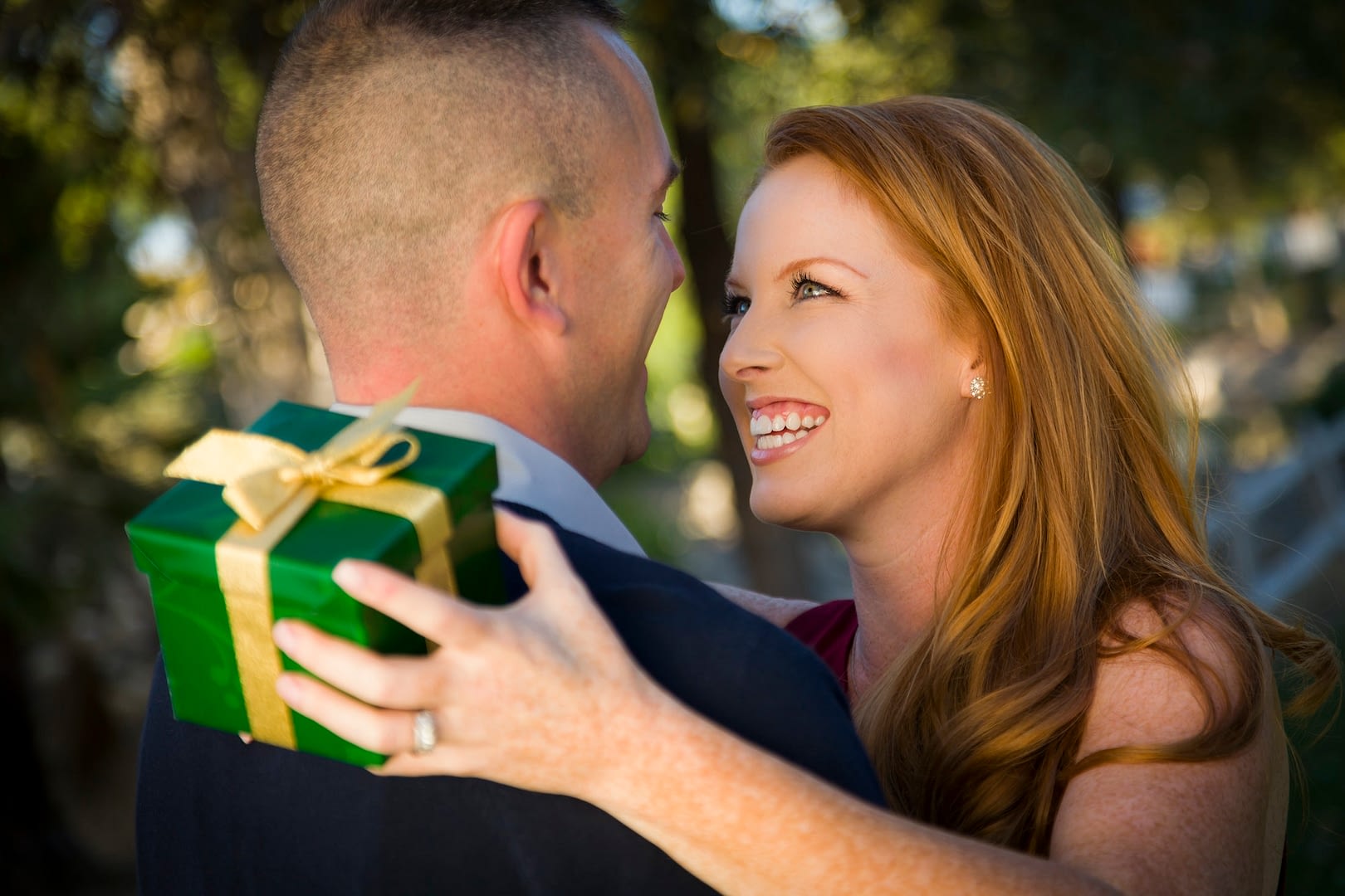 smiling beautiful young woman and handsome military man exchange a christmas gift