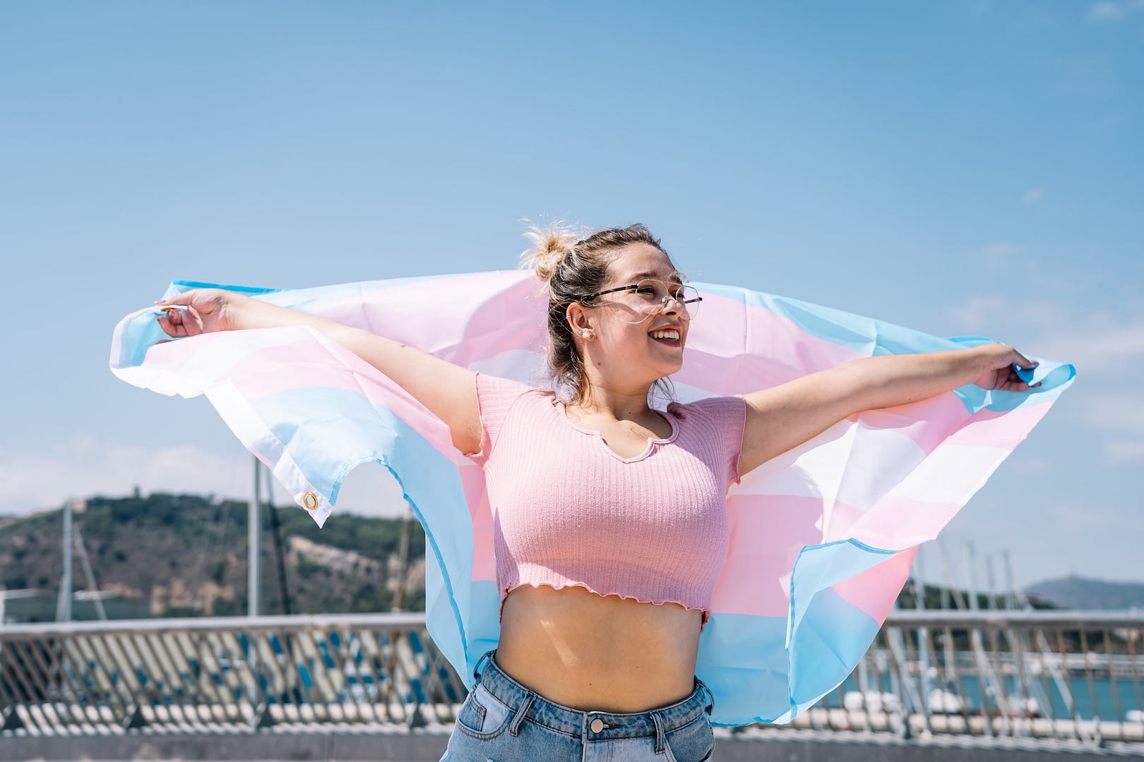 transsexual woman with trans flag holding a transgender pride flag