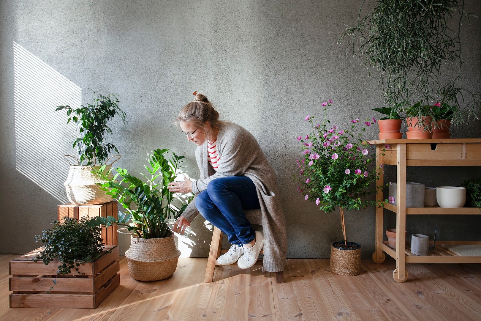 woman tending to potted plants in indoor garden