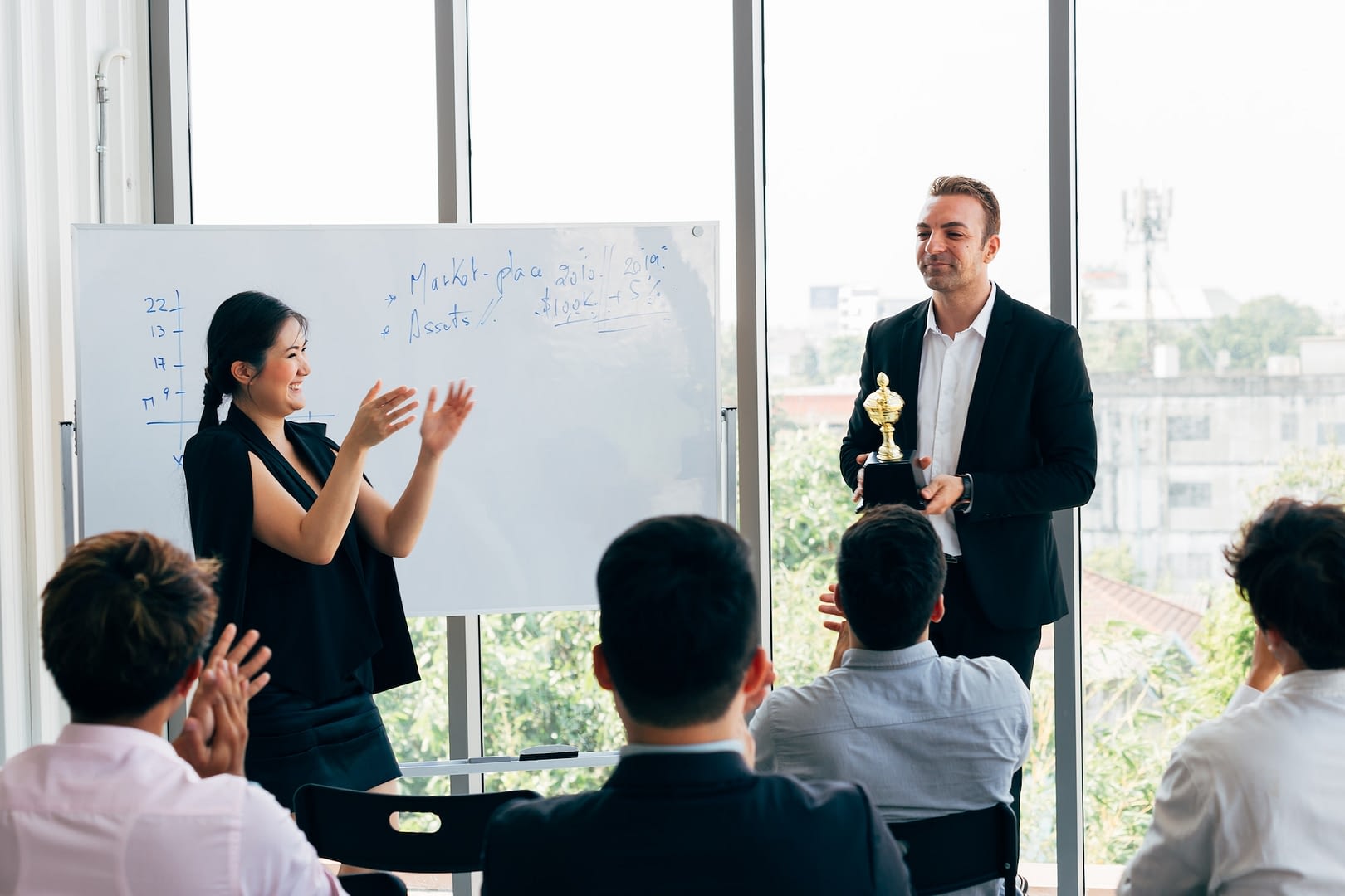 boss awarding workers during conference