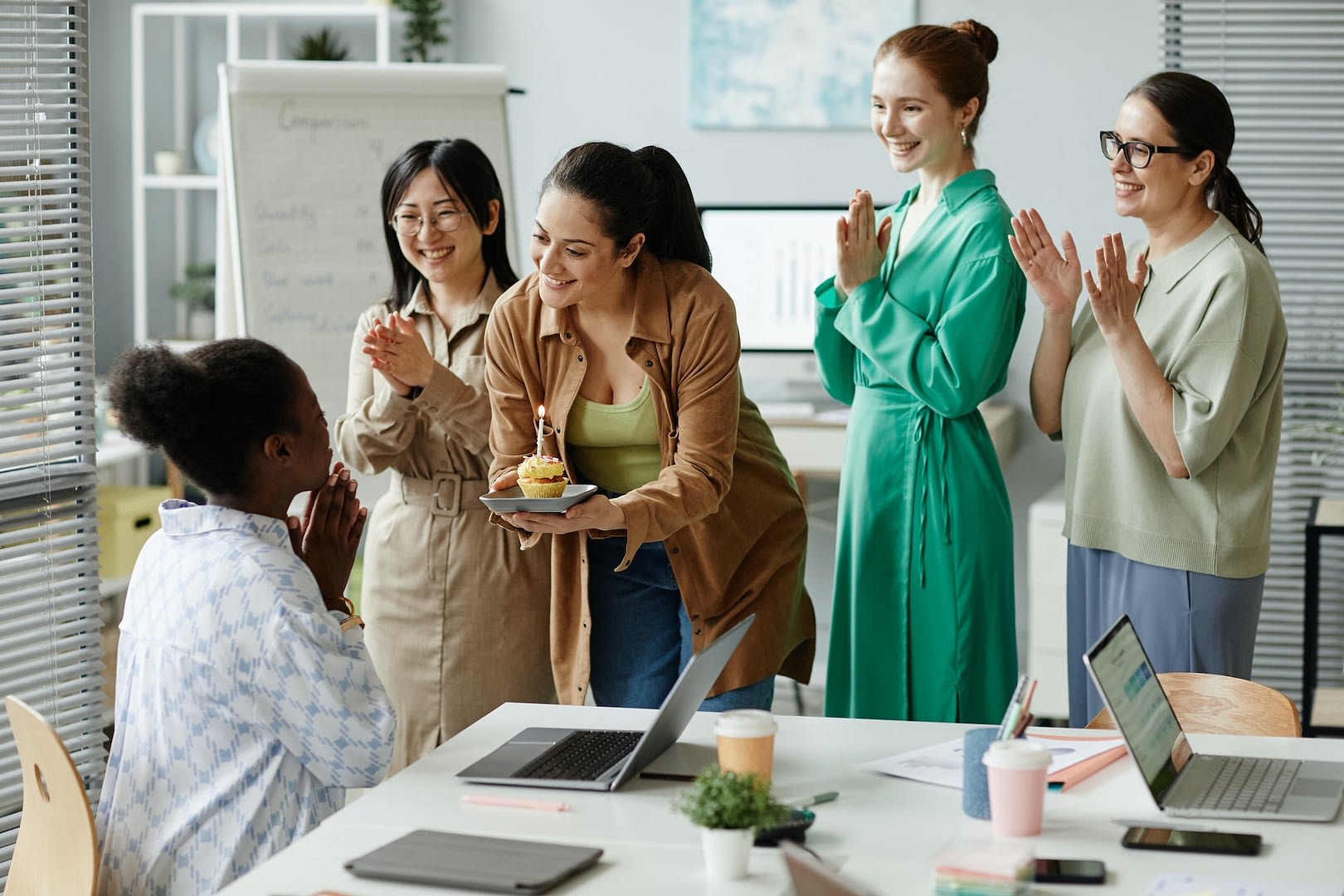businesswomen congratulating their colleague at office