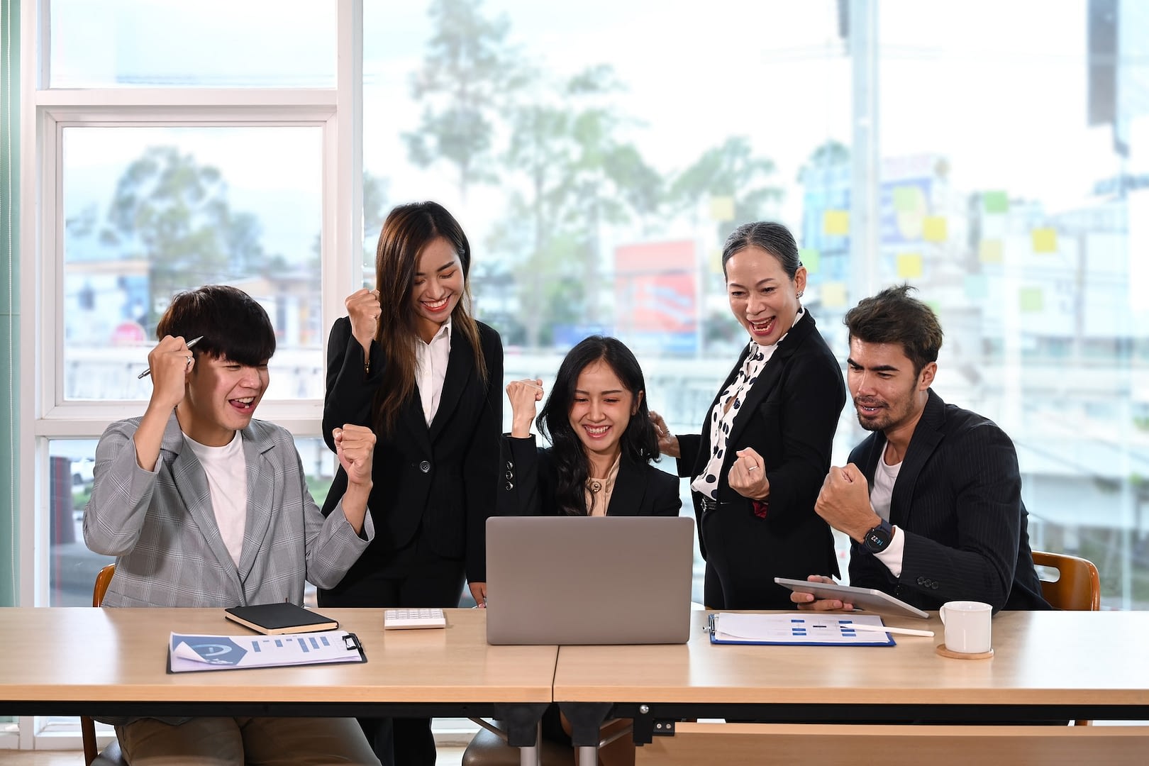 diverse employees celebrating business success or victory together in office