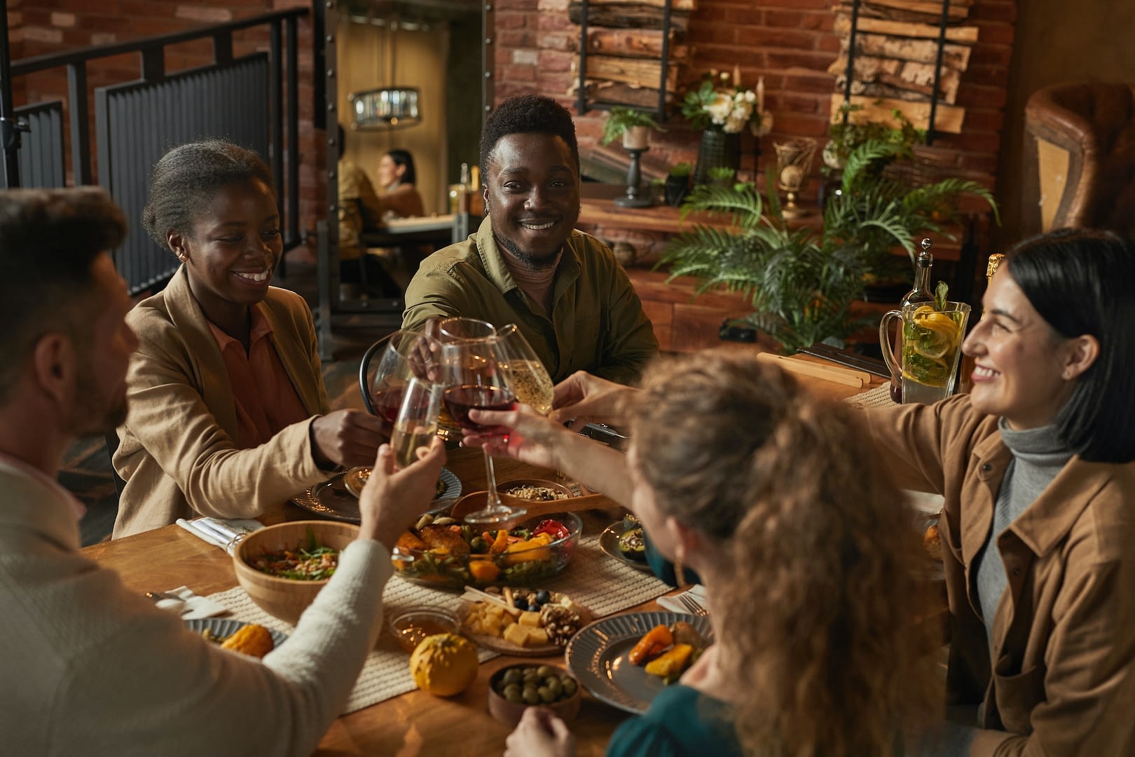 group of friends toasting at dinner party