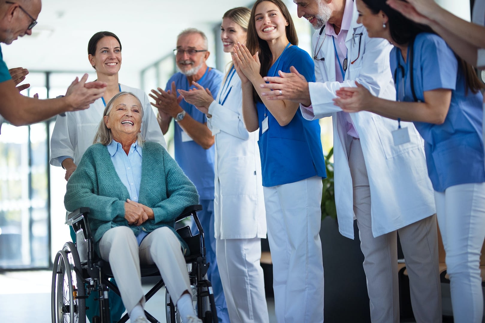 medical staff clapping to patient who recovered from serious illness