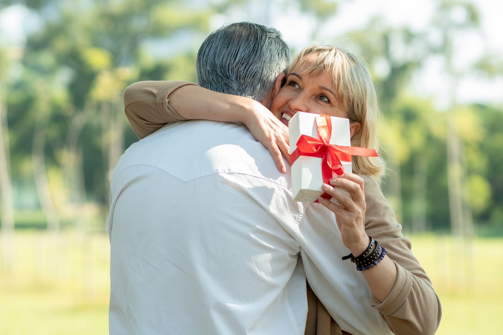 thank you my love for this gift happy senior couple hugging in park in romantic