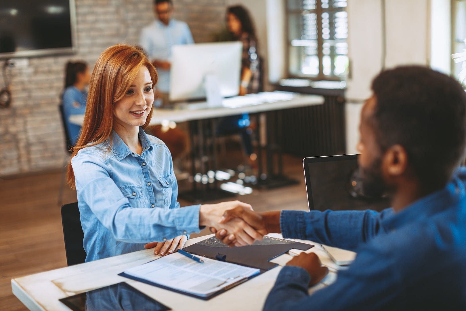 young woman signing contracts and handshake with a manager