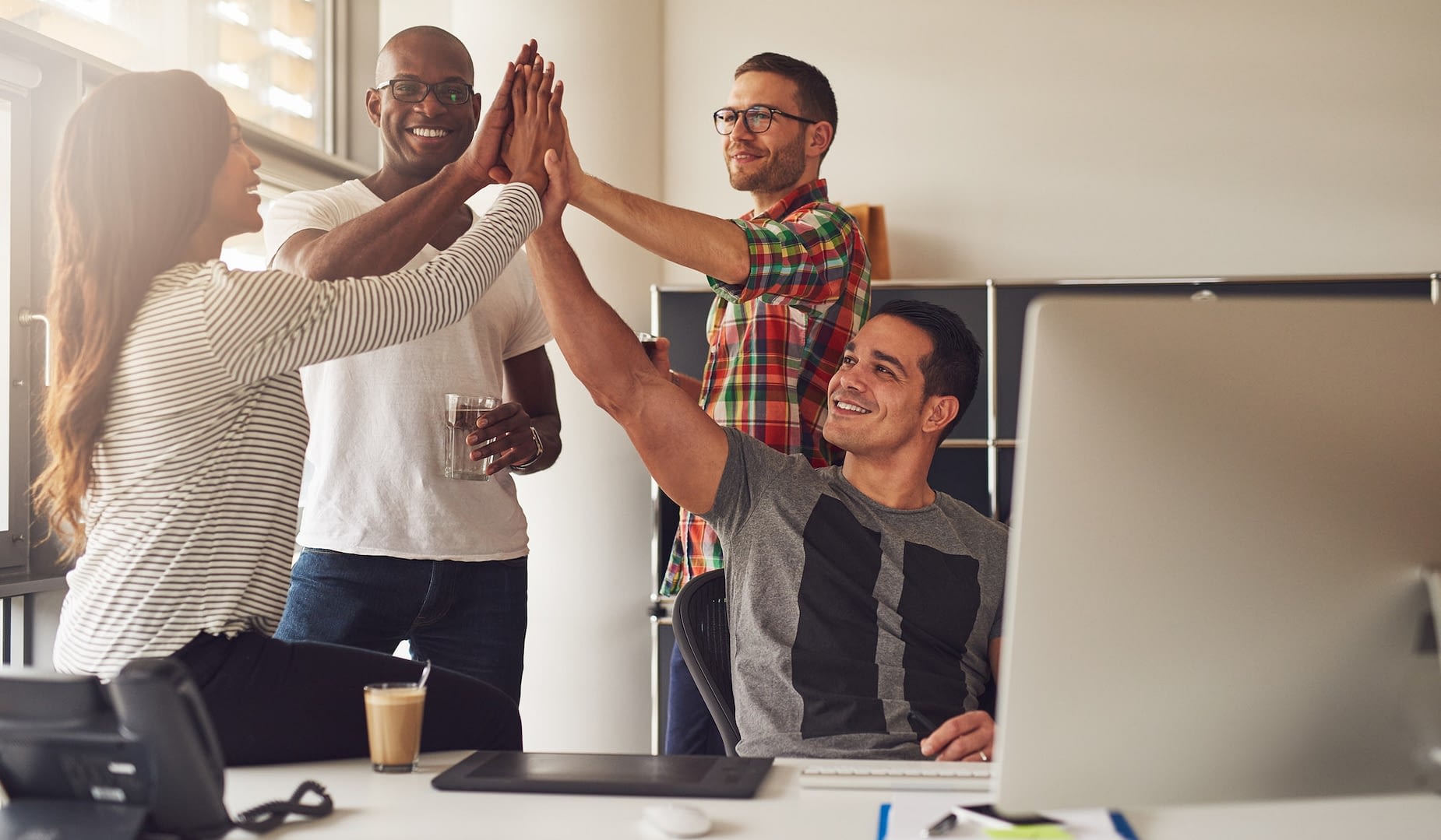 diverse workers celebrating something in office