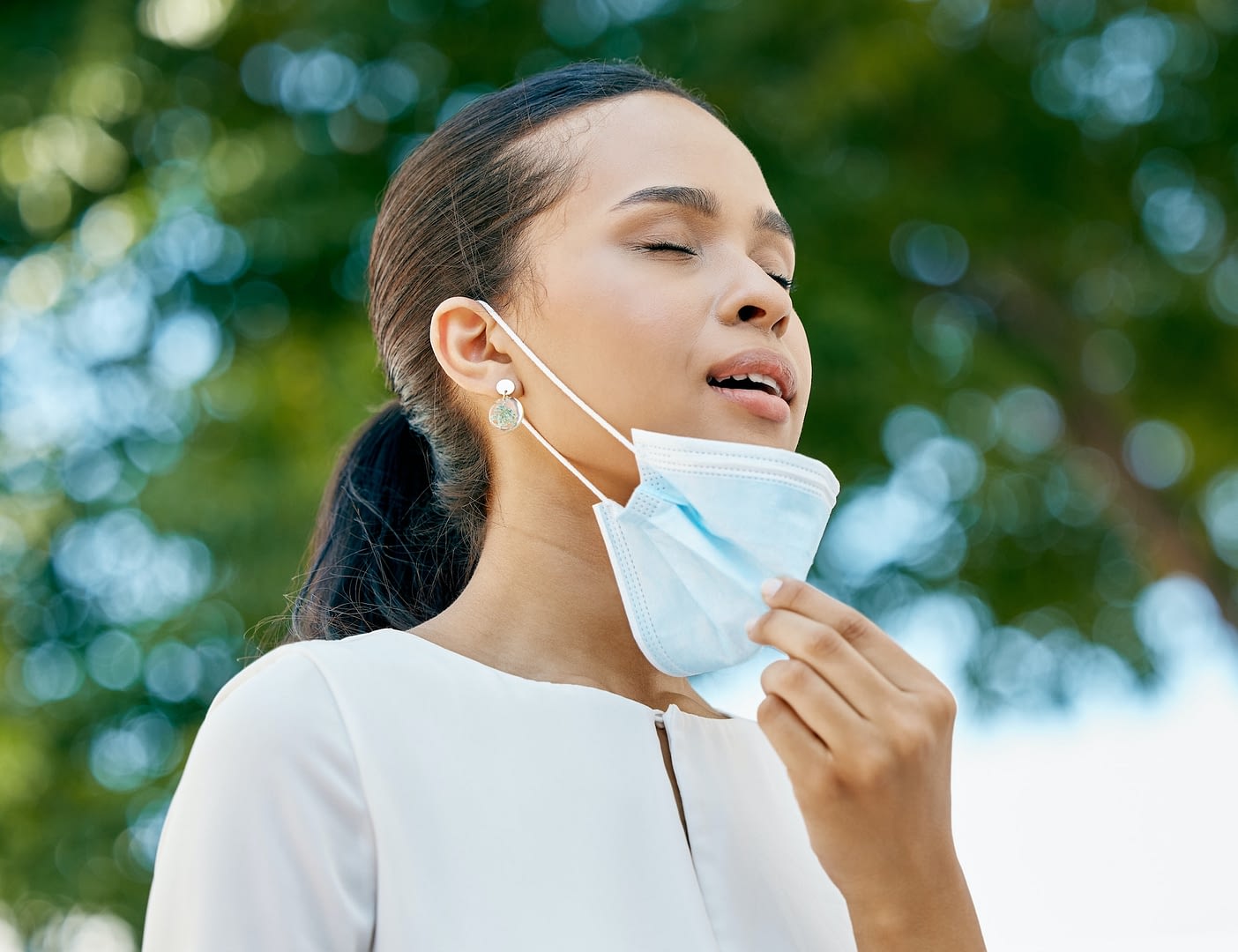 covid removing face mask and breathing air in park for healthcare lung wellness and outdoor clean