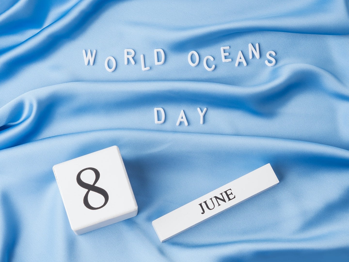 world oceans day in white letters on blue wave textile june 8 holiday