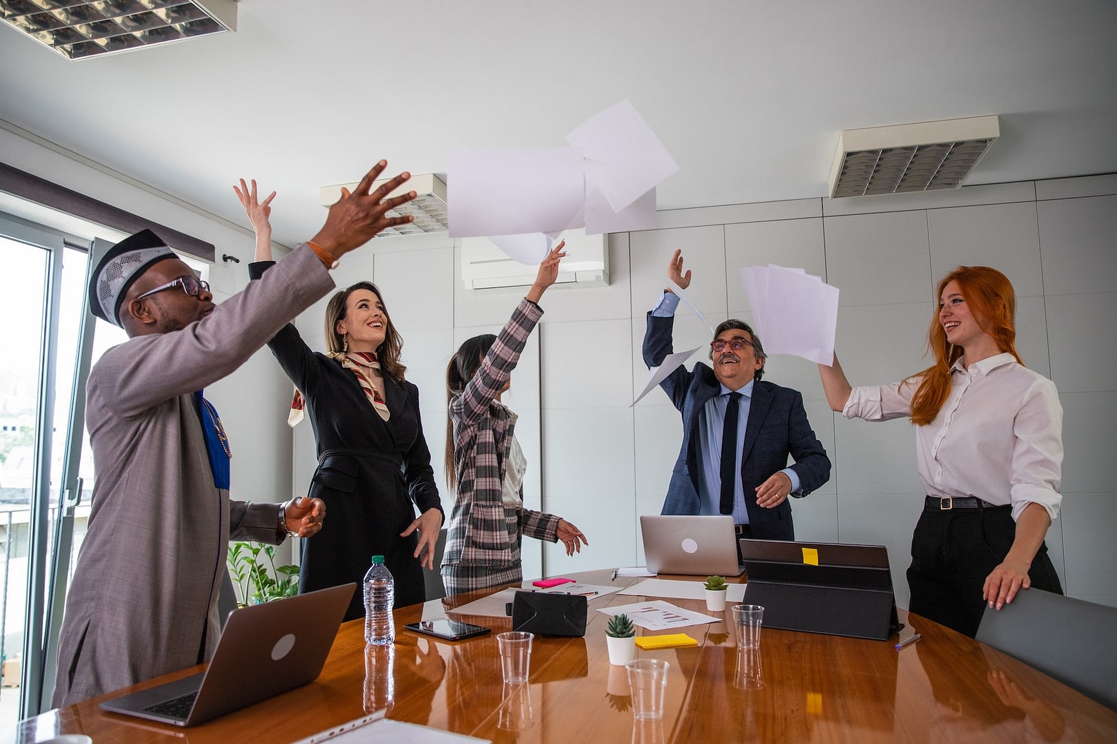 a group of business people celebrate a business achievement by throwing papers in the air