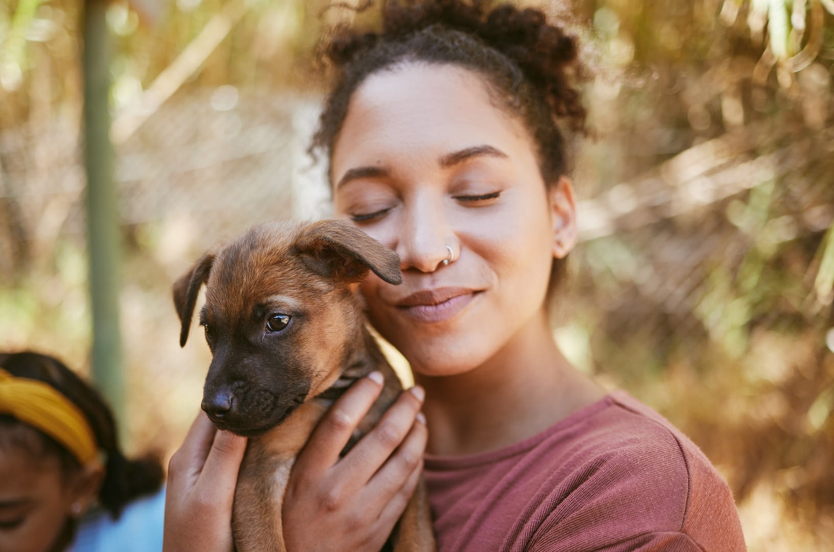 love dog and animal shelter with a black woman hugging a foster pet while at a shelter to adopt a