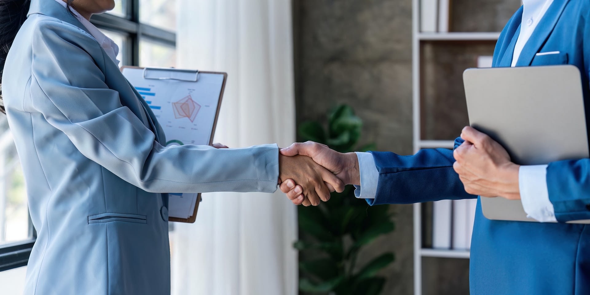 business young woman signing contracts and handshake with a manager man